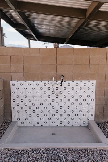 A shower area with a tile wall and a shower head.